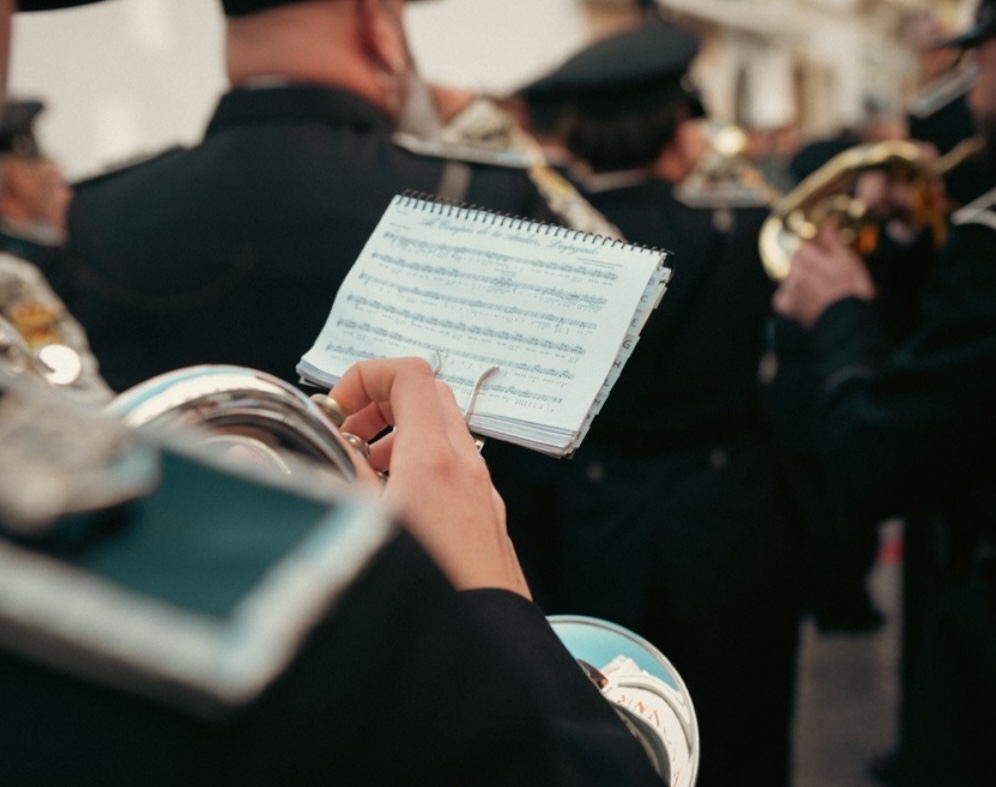 Un componente sigue la partitura en un atril portátil durante un ensayo.